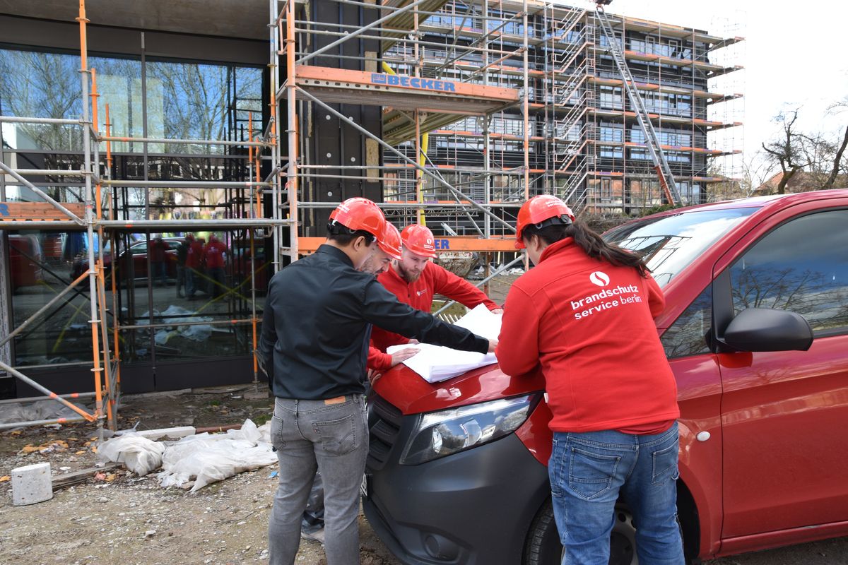 Team an der Baustelle, Pläne auf dem Fahrzeug