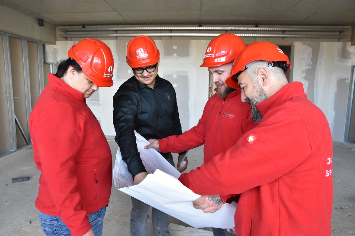 Team bei der Planbesprechung im Rohbau