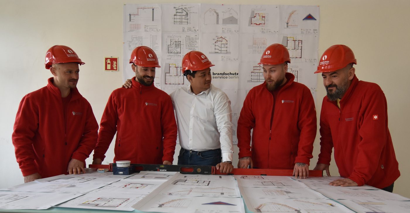 Das Team von Brandschutz Service Berlin bei der Projektbesprechung mit Bauplaenen
